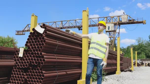 El trabajador da instrucciones a la grúa pórtico, el control de movimiento de la grúa pórtico con la ayuda de gestos, el hombre trabaja en el almacén — Vídeos de Stock