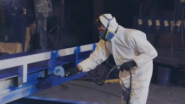 Um homem pinta uma grande parte, uma pistola de pulverização, pintando uma grande parte de metal — Vídeo de Stock