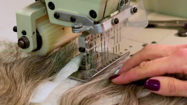 Coudre une perruque sur une machine à coudre, une femme produit une perruque — Video