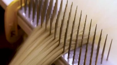 Peruk yaparken saç tarama. Fabrika peruk üretim süreci