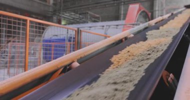 Fabrikada taşıma bandı hattı, kum ve metal toplarla taşıma bandı.