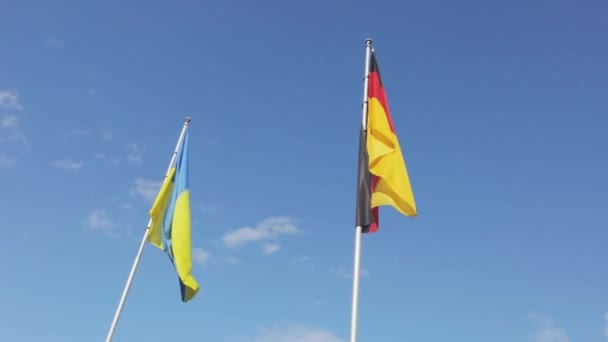 Bandiera ucraina e tedesca sventola isolata con cielo blu sullo sfondo. Germania, Deutschland — Video Stock