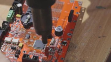 Mühendis bir levhayı lehimliyor, bir mikro devreyi lehimlemeye yakın plan, bir mikro devre yakın çekim montajı.