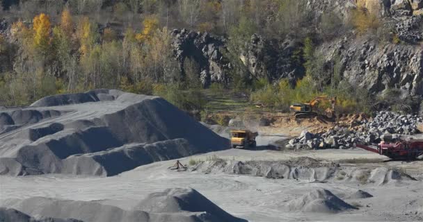 Yellow dump truck rides in granite quarry, working process in granite quarry — Stock Video