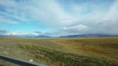 Araba camından patagonya tarlaları, yol kenarındaki bir arabanın gölgesi.