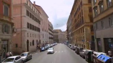 Roma sokaklarında arabayla bir gezi. Roma sokakları bir arabanın penceresinden görünüyor. Roma 'da insanlar sokaklarda yürüyor. Roma 'nın eski sokakları.