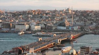 Gün batımında Galata Köprüsü ve camilerin manzarası. Bir sürü martı uçuyor, turist tekneleri yüzüyor. İstanbul, Türkiye. 10 Nisan 2019