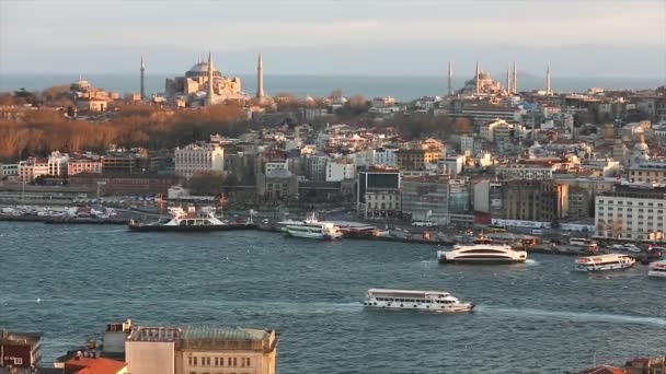 Ein weites Bild von Istanbuls Kathedralen und der Meerenge vom Goldenen Horn am Abend zur goldenen Stunde. Die Abendsonne erhellt die Blaue Moschee und die Hagia Sophia. — Stockvideo