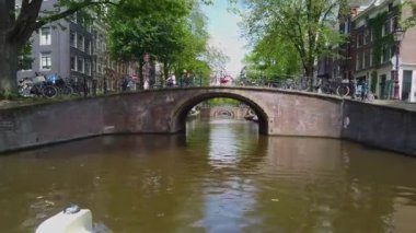 Nehrin üzerindeki köprü, Amsterdam. Amsetrdam 'da insanlar sokaklarda yürüyor