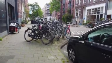 Amsterdam caddesi boyunca park edilmiş bisiklet ve arabalar. Amsterdam Caddesi, Amsterdam 'ın güzel sokakları..