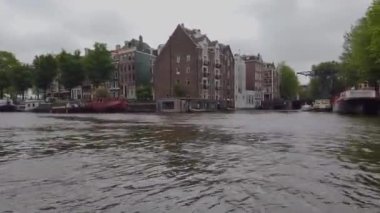 Amsterdam 'ın dış binaları. Amsterdam 'da bir teknede. Amsterdam kanalları boyunca tekne gezisi.