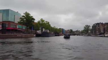 Amsterdam 'ın dış binaları. Amsterdam 'da bir teknede. Amsterdam kanalları boyunca tekne gezisi.
