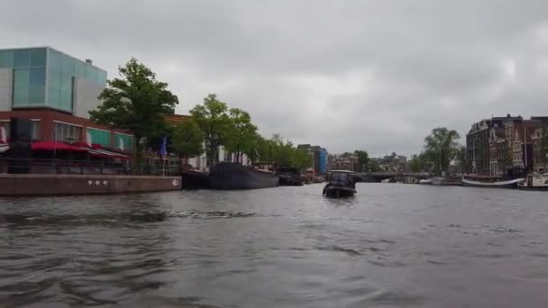 Amsterdam 'ın dış binaları. Amsterdam 'da bir teknede. Amsterdam kanalları boyunca tekne gezisi. — Stok video