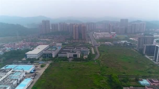 Sobrevuelo de pequeñas fábricas chinas, montañas y zona residencial en el fondo — Vídeo de stock