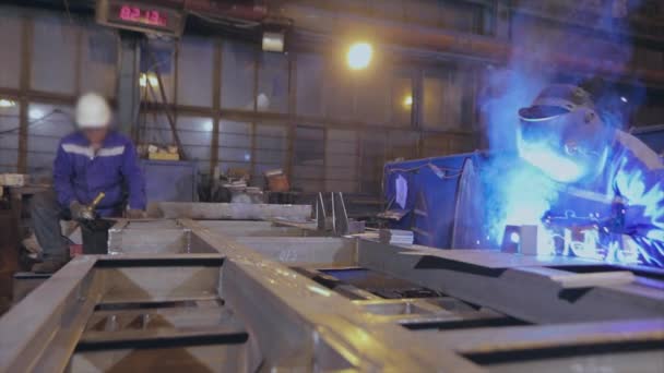 Металлообработка на заводе, два работника выполняют металлообработку — стоковое видео
