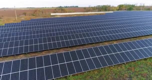 Vista da central solar de cima, voo sobre uma grande estação solar perto da floresta — Vídeo de Stock