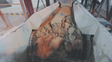 Kum ve metal toplarla taşıma bandı. Fabrikadaki taşıma bandı hattı.