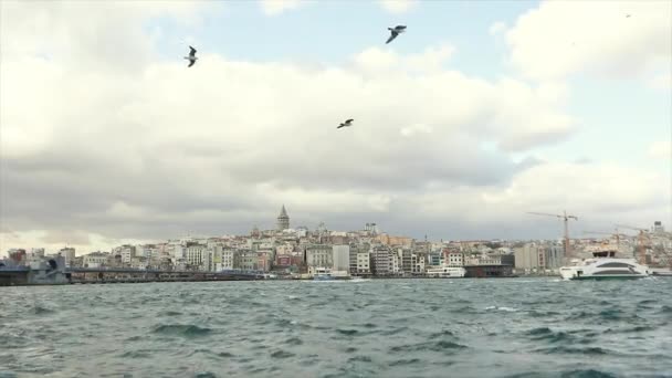 Een groot modern jacht vaart langs de Bosporus, op de achtergrond is de Galata Toren. Baai gouden hoorn — Stockvideo