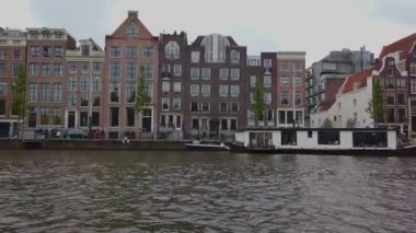 Amsterdam 'ın dış binaları. Amsterdam 'da bir teknede. Amsterdam kanalları boyunca tekne gezisi.
