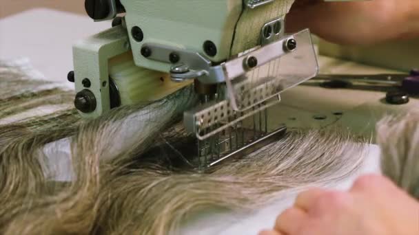 Женщина пришивает волосы к основанию парика — стоковое видео