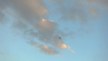 Gökyüzündeki İHA 'lar güzel bulutların arkaplanına karşı. Renkli bir gökyüzünün arka planında askeri UAV