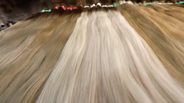 Светлые волосы для наращивания, светлые натуральные волосы для наращивания на стенде — стоковое видео