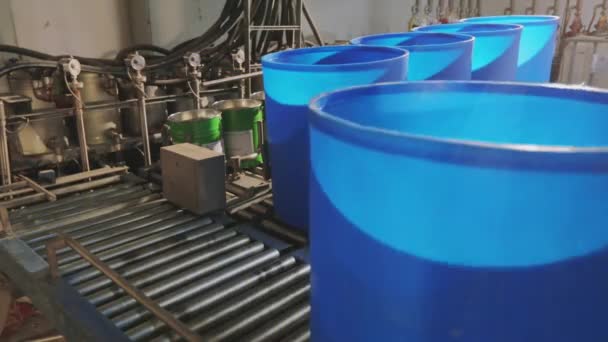 Het kleurproces in de fabriek, Witte verf wordt gegoten in een emmer, het proces van het gieten van verf naar de fabrieken — Stockvideo