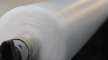 Dokumasız kumaş ruloları tüpe itiliyor. Örülmemiş kumaş üretimi