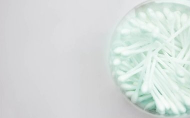 Beyaz temizleme bezi pamuk uçlu. Kulak yakın savunuyor. Yumuşak odak resim.