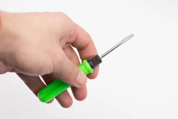 Kırpma izole üzerinde beyaz zemin üzerine yeşil tutamacın tornavida tutan el