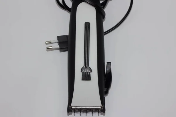 Immagine in primo piano del braccio che tiene il tagliacapelli, isolato su sfondo bianco, un tagliacapelli elettrico in mano per parrucchieri — Foto Stock