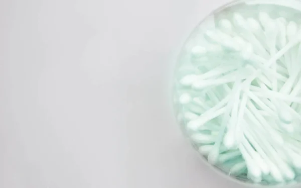 Beyaz temizleme bezi pamuk uçlu. Kulak yakın savunuyor. Yumuşak odak resim.