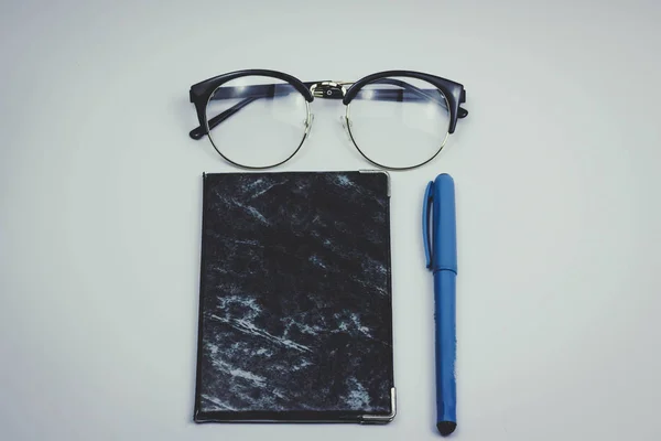 Bir iş kavramı. Tablet pc, fincan kahve, gözlük, kalem ve defter üzerinde yazılı ahşap masa ile.