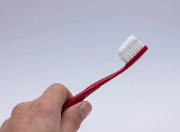 Toothpaste on a toothbrush close-up on a blue light — Stock Photo, Image