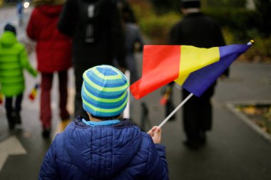 Romanya Ulusal Günü askeri geçidinde genç bir çocuk Romanya bayrağı sallıyor