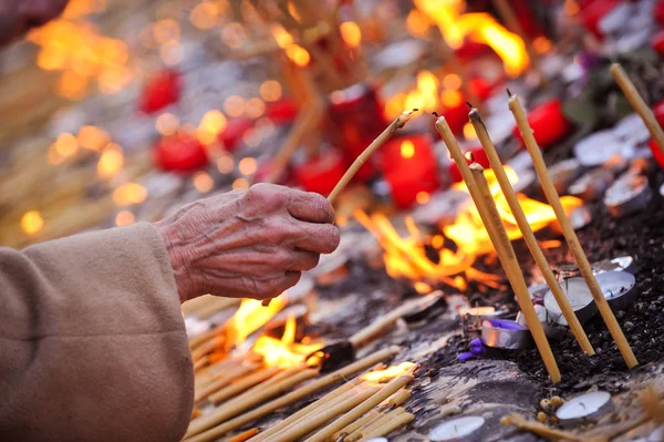 La gente accende candele in un cortile della chiesa — Foto Stock