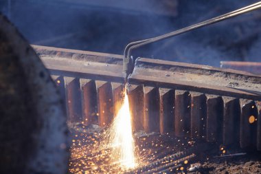 İşçi hurdalıkta meşale kesmek için oksikodon asetilen kullanıyor.