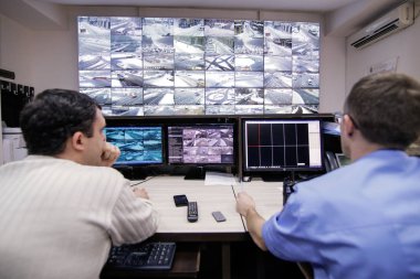 Romanya 'nın Bükreş kentinde karlı bir kış gününde yol trafiğinden canlı görüntüler izleyen iki kişi görülüyor