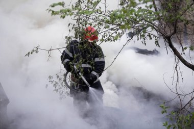 BÜKREŞ, ROMANIA - 17 Nisan 2017 'de Bükreş' te, ıssız bir eve yayılan bir yangını suyla söndürmeye çalışan itfaiyeciler