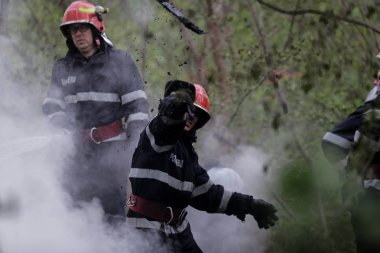BÜKREŞ, ROMANIA - 17 Nisan 2017 'de Bükreş' te, ıssız bir eve yayılan bir yangını suyla söndürmeye çalışan itfaiyeciler