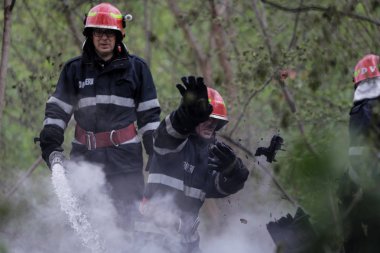 BÜKREŞ, ROMANIA - 17 Nisan 2017 'de Bükreş' te, ıssız bir eve yayılan bir yangını suyla söndürmeye çalışan itfaiyeciler