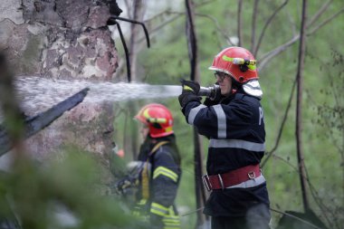 BÜKREŞ, ROMANIA - 17 Nisan 2017 'de Bükreş' te, ıssız bir eve yayılan bir yangını suyla söndürmeye çalışan itfaiyeciler