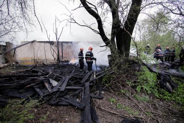 BÜKREŞ, ROMANIA - 17 Nisan 2017 'de Bükreş' te, ıssız bir eve yayılan bir yangını suyla söndürmeye çalışan itfaiyeciler