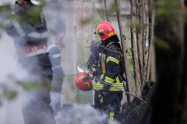 BÜKREŞ, ROMANIA - 17 Nisan 2017 'de Bükreş' te, ıssız bir eve yayılan bir yangını suyla söndürmeye çalışan itfaiyeciler