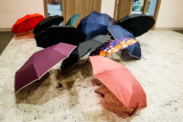 Umbrellas laid to dry outside the entrance of an office, in a mo
