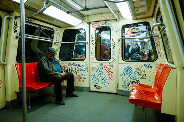 Ein Mann ist in einem schmutzigen und alten U-Bahn-Waggon voller Graffiti unterwegs — Stockfoto