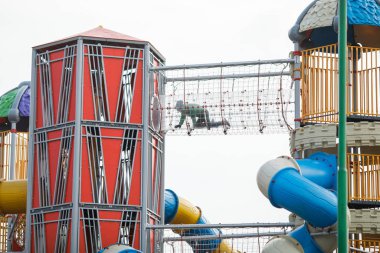 Kid crawling inside a transparent tube in a colorful children pl