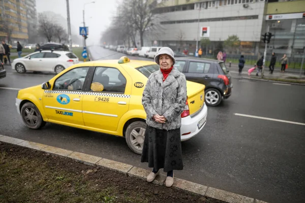 Profundidad superficial de la imagen de campo con una mujer mayor de pie en una c — Foto de Stock