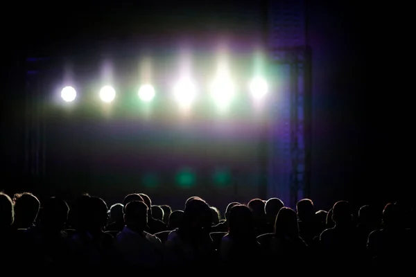Silhouettes de personnes sous des lumières d'arrière-plan lumineux — Photo