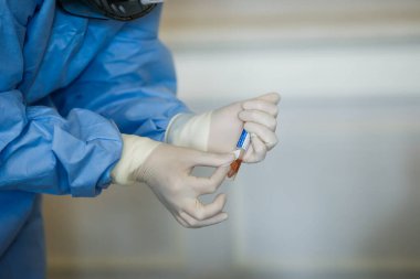 Bükreş, Romanya - 13 Mart 2020: Bir kişi üzerinde koronavirüs testi uygulayan bir sıhhiyenin elleriyle ayrıntılar.